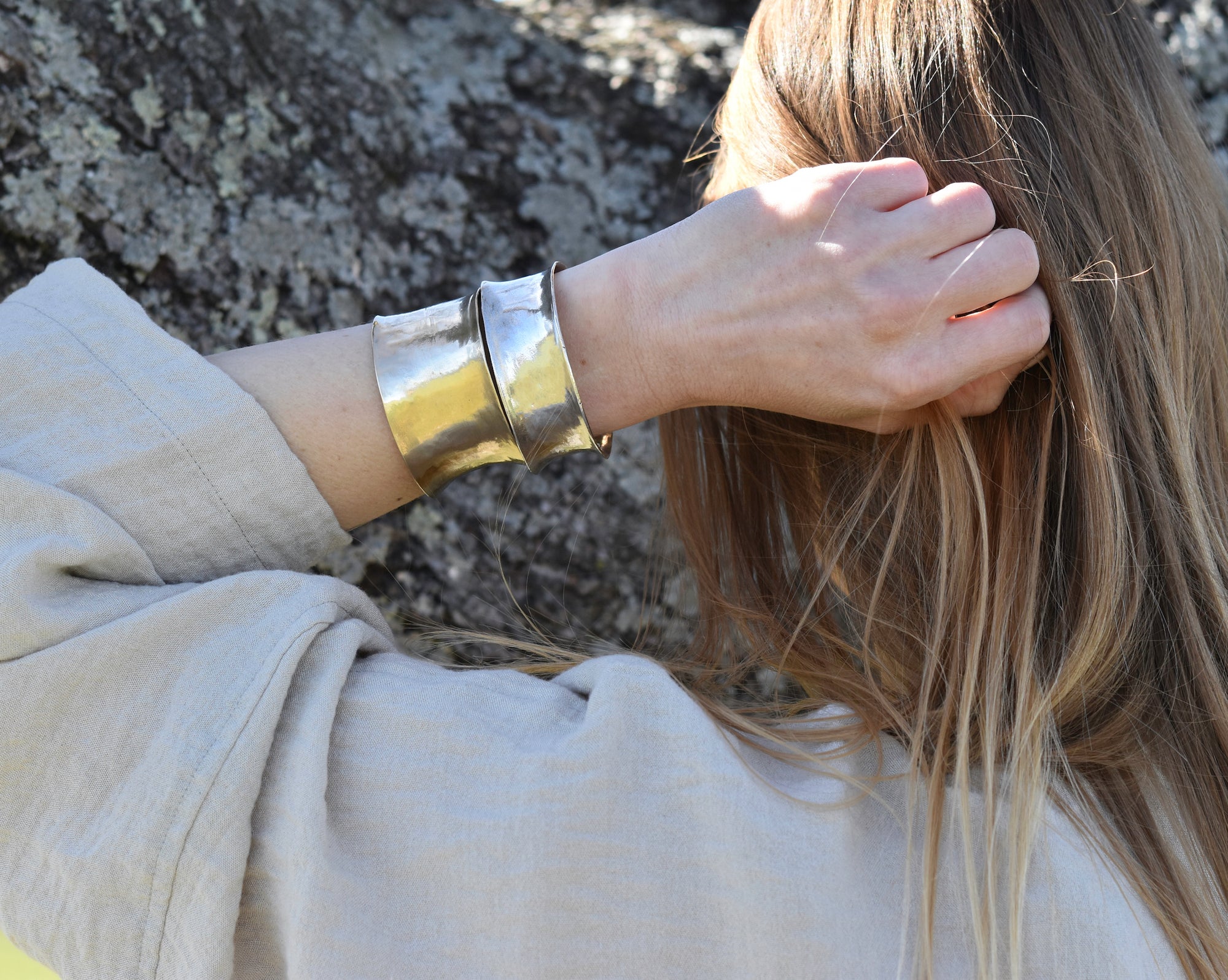Model wearing both a silver and brass cuff, each in a different width, to show the scale and tonal difference.