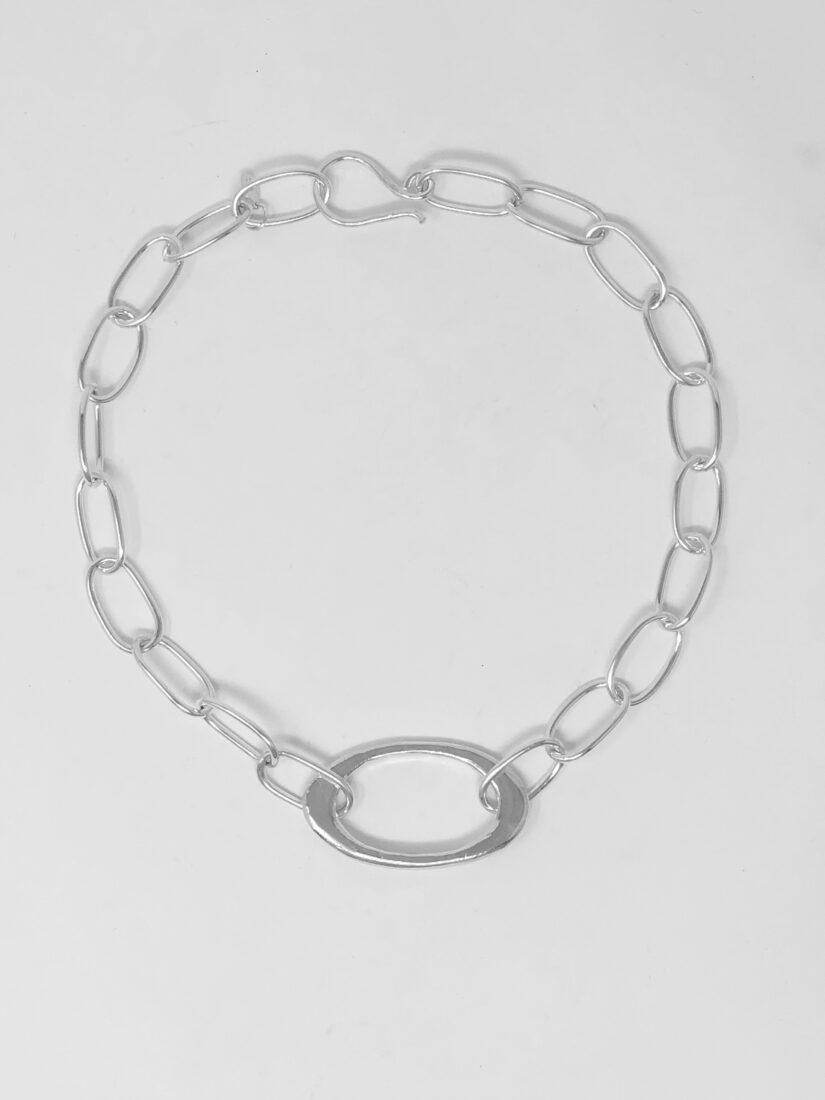 Flat lain image of the sterling silver fiona necklace showing the handmade wire links and the statement oval in the center