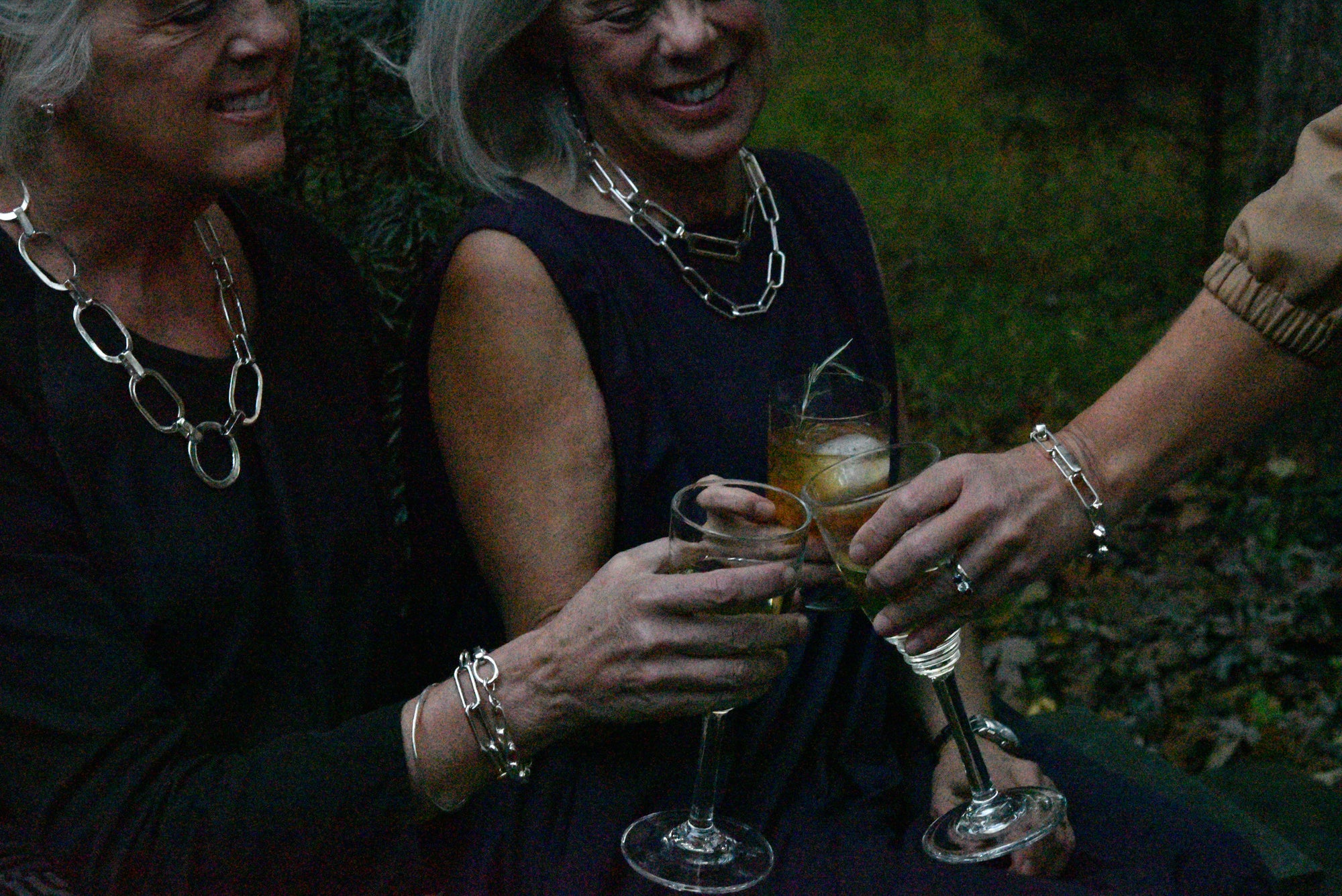 An image of three ladies wearing liz hanson metalsmith jewelry, celebrating something big, rejoicing. Each wearing a signature sterling silver statement jewelry look.