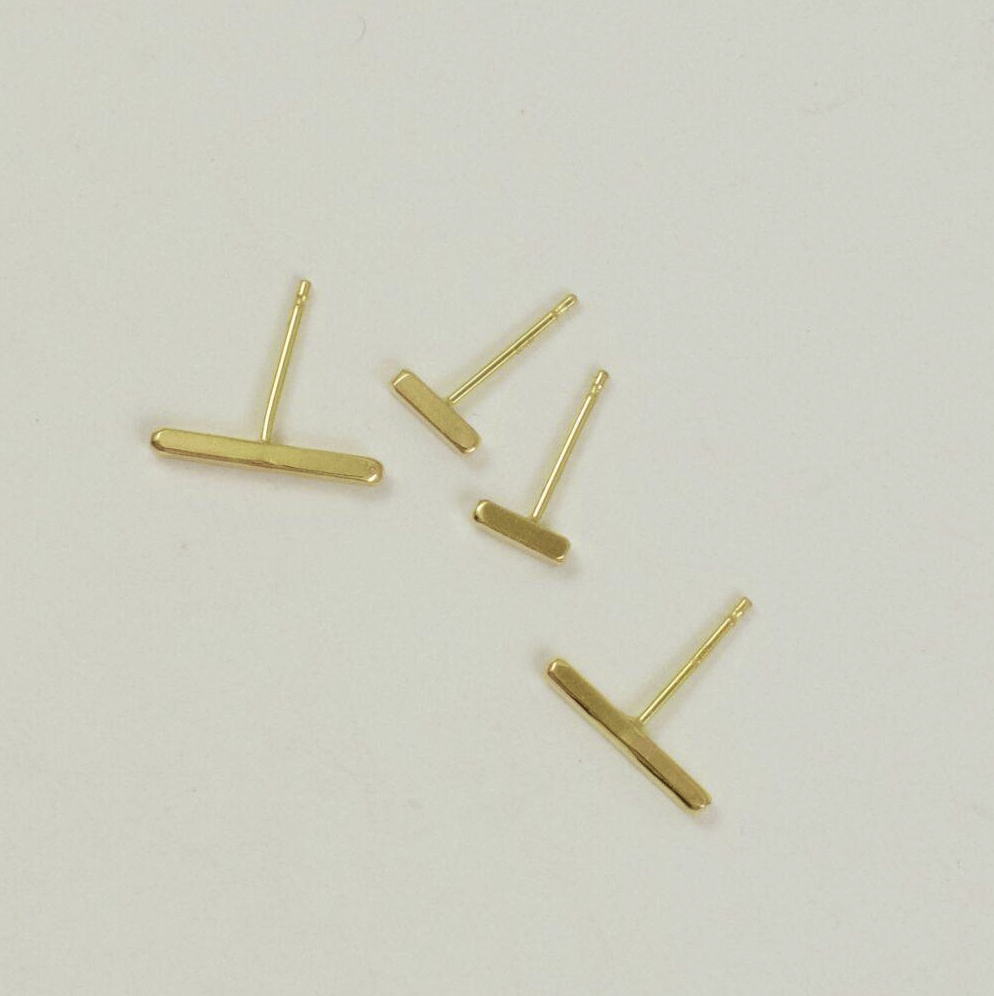 Flat lain photo of both sizes of the 18 karat gold square wire stud earrings that shows the relative size difference.