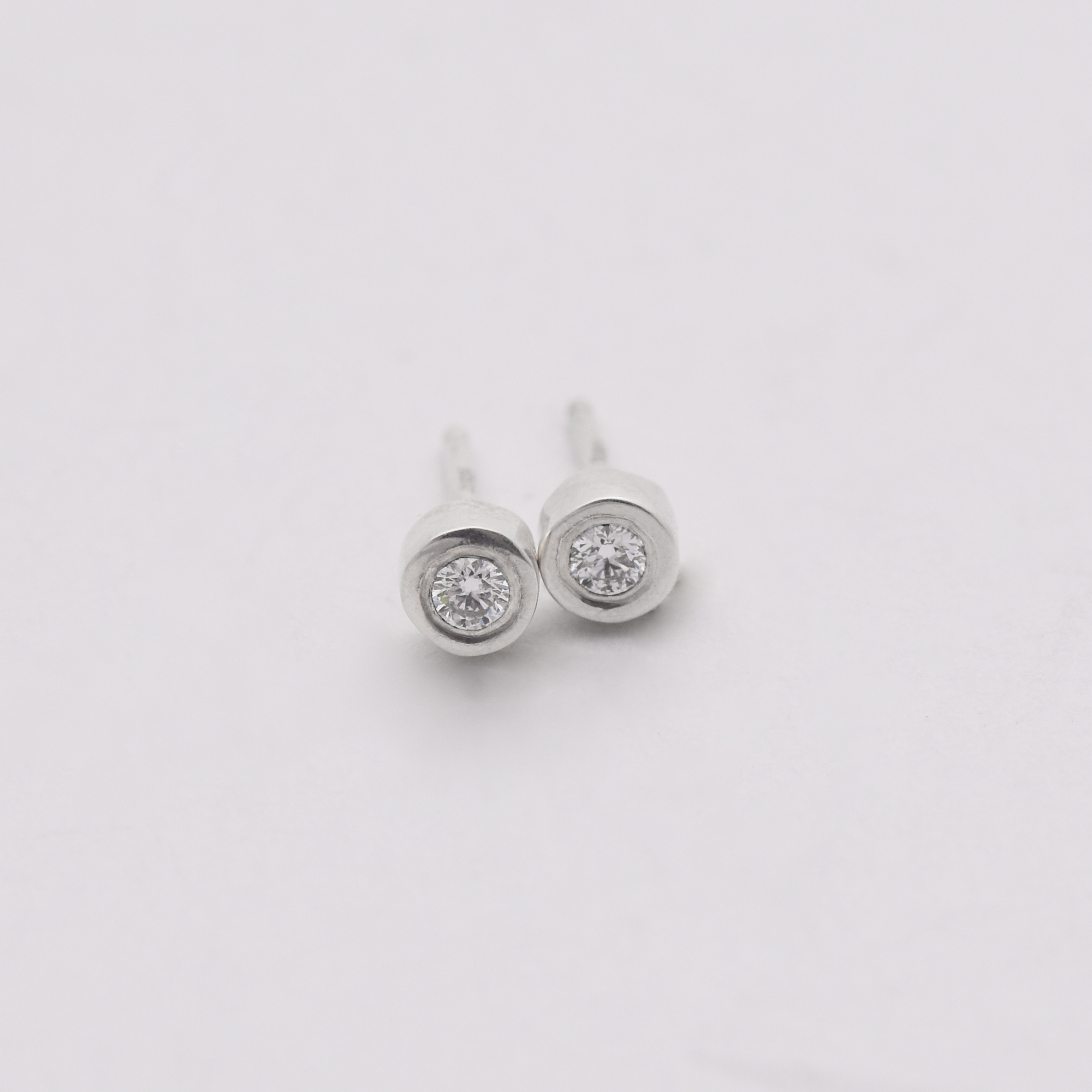 2.5 mm lab grown diamond studs set in an organically carved and solid cast sterling silver or 18k gold setting. 