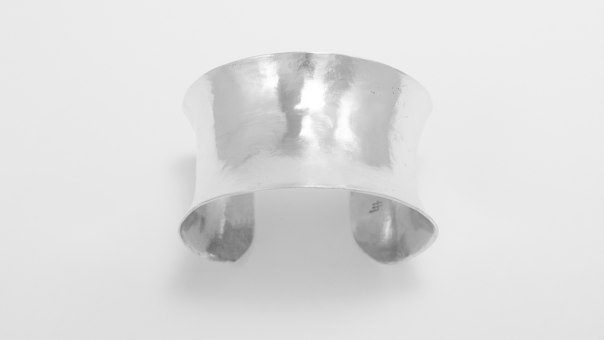 An image of the hand forged and hammered anticlastic 1.5 inch cuff