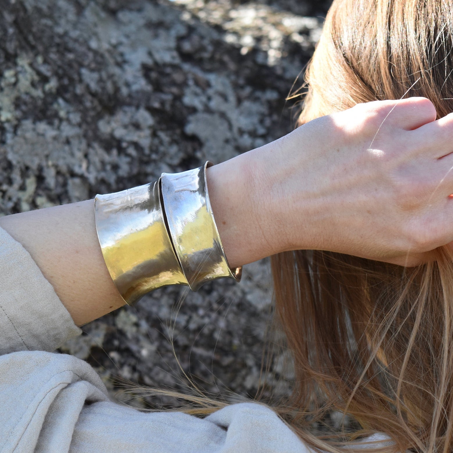 Model wearing both a silver and brass cuff, each in a different width, to show the scale and tonal difference.
