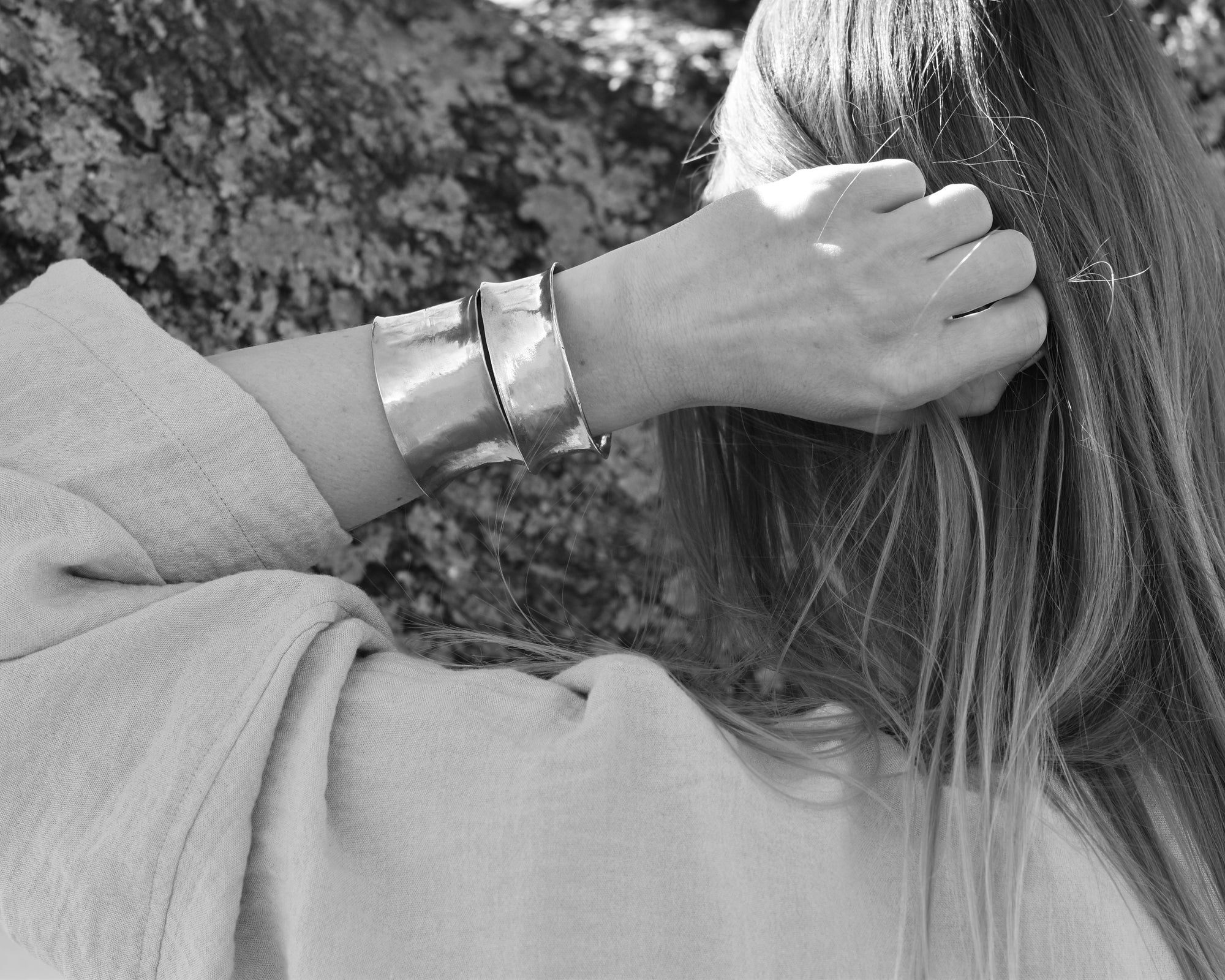 An image of a model wearing both the 1 inch and 1.5 inch cuffs in a stack.