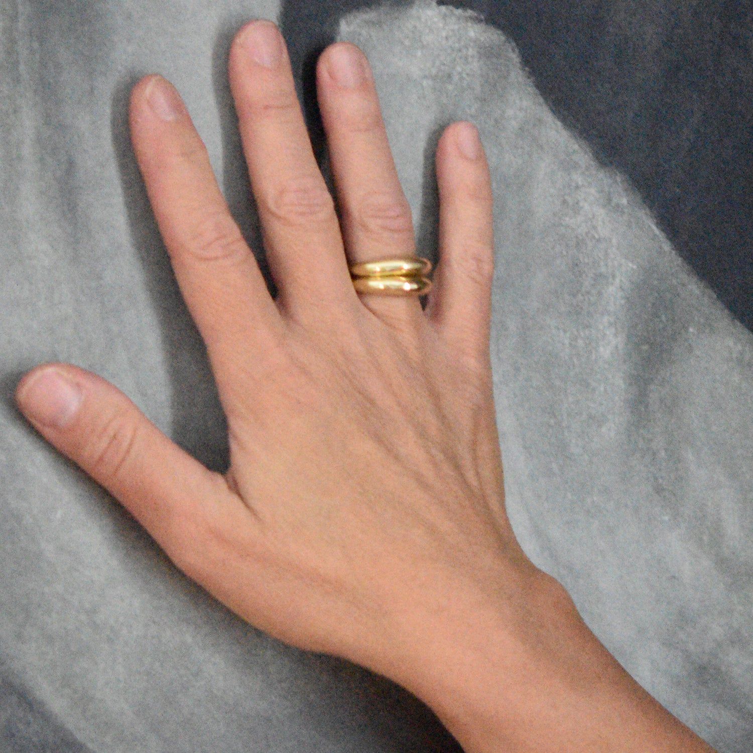 A photo of the 18k gold cast ring on a model's hand for scale.