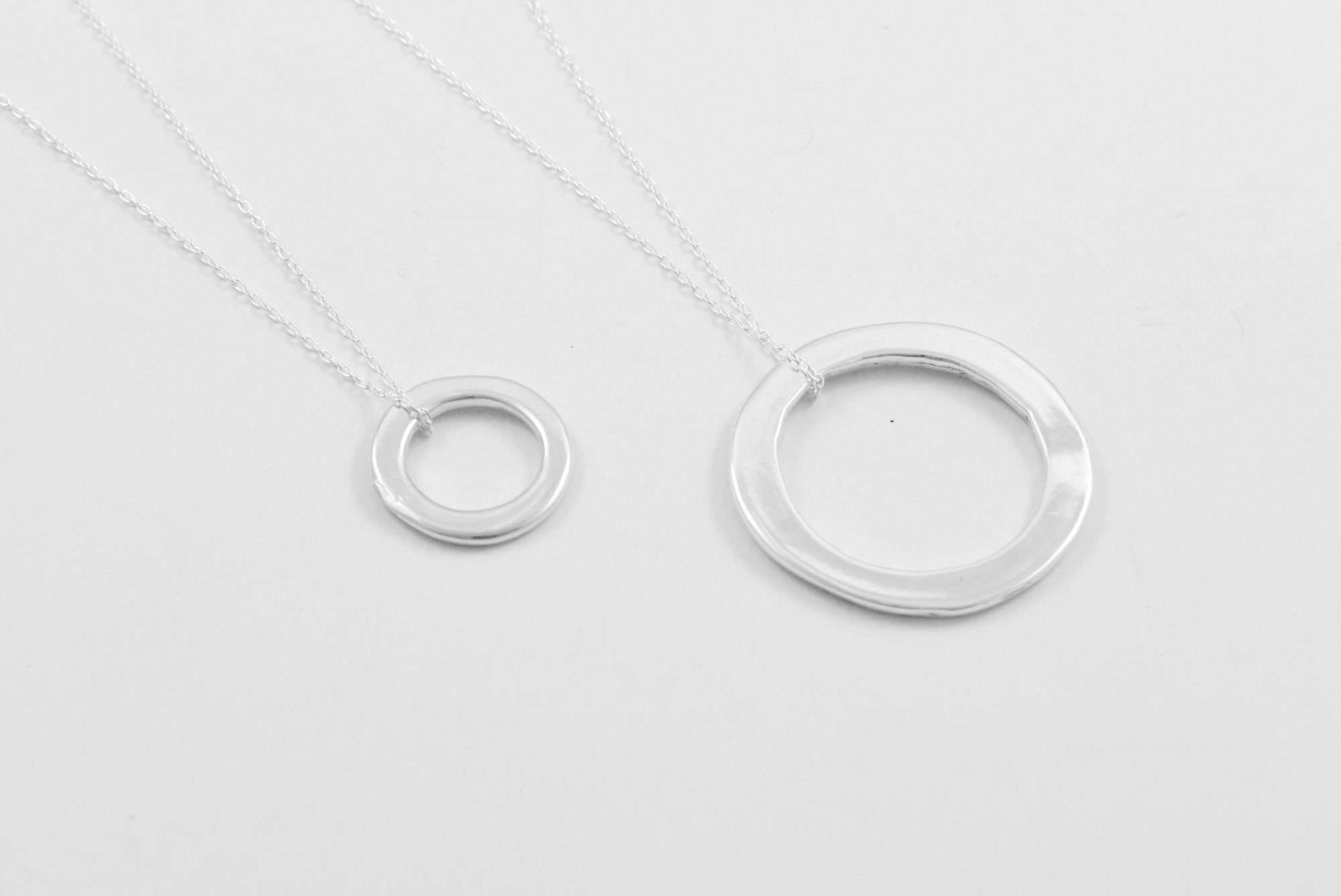 Both sizes of the Ina necklace lain flat to show the relative size difference between them, as well as the clever way the chain is attached.