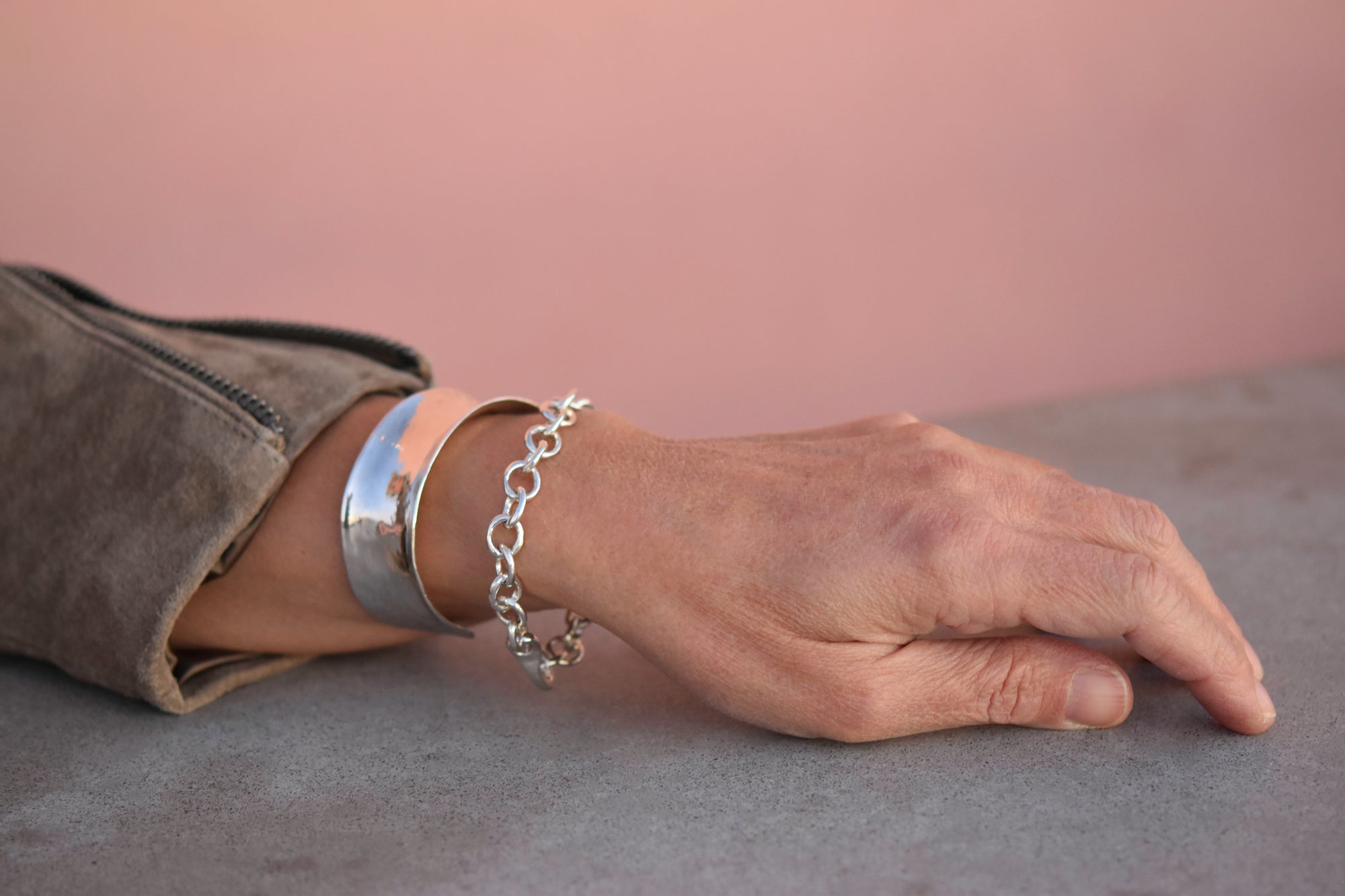 An image of a model wearing both the 1 inch stering silver hammered cuff with the little sister bracelet.