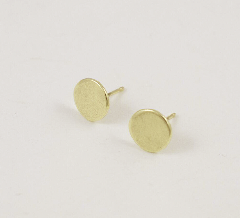 Flat lain photo of the mini petal earrings that shows the delicate brushed matte texture of the surface.