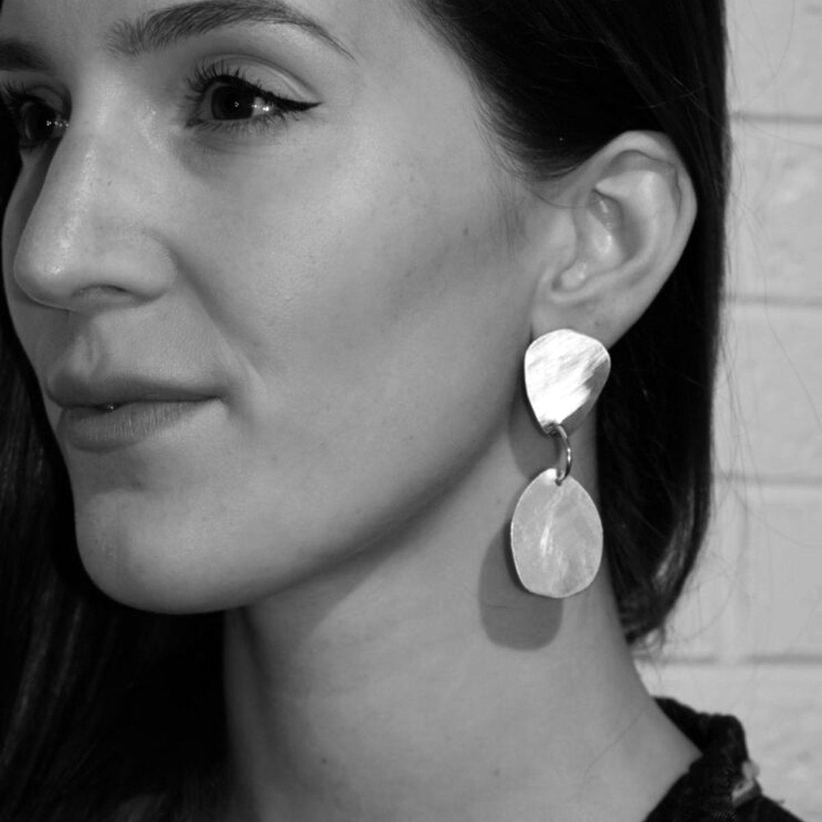 Image shows Organic Drop earring on a model for scale, as well as the light catching quality of the brushed matte finish. 