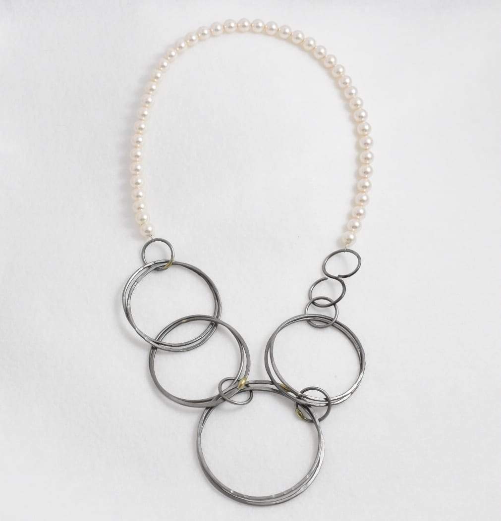 Flat lain close up of the genuine Sworovski Pearl and Steel Circle necklace.